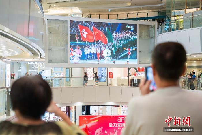 11月9日晚,香港市民在观塘的一家商场内通过大屏幕观看在广州举行的第十五届全国运动会开幕式。图为大屏幕显示出粤港澳三地运动员代表团一同入场。 中新社记者 侯宇 摄 11月9日晚,香港市民在观塘的一家商场内通过大屏幕观看在广州举行的第十五届全国运动会开幕式。图为大屏幕显示出粤港澳三地运动员代表团一同入场。 中新社记者 侯宇 摄