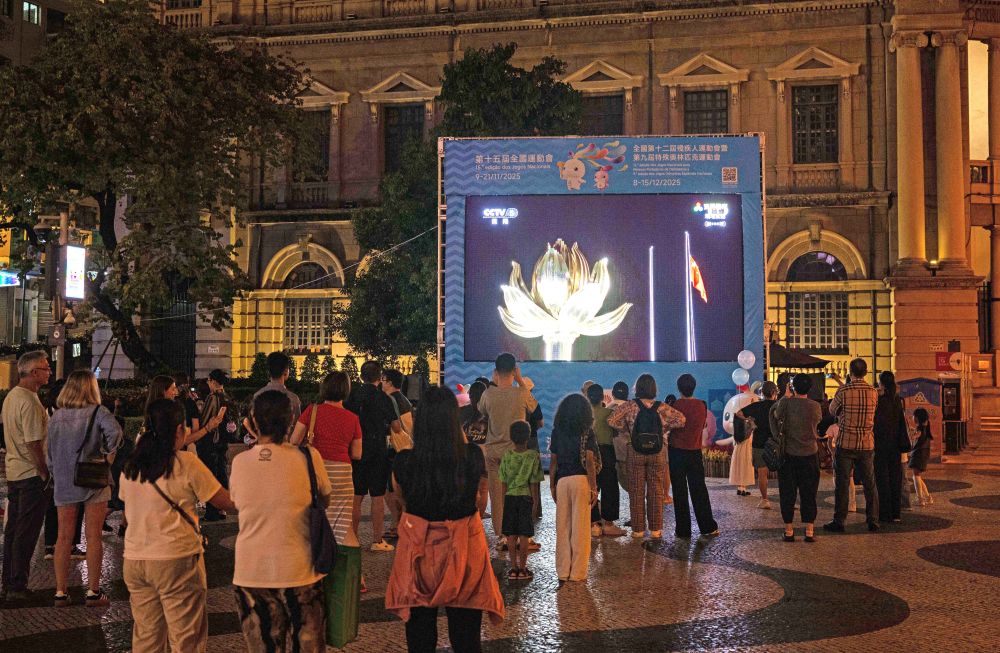 11月9日，第十五届全国运动会开幕式在广东奥林匹克体育中心举行，这是群众在澳门街头观看直播。新华社发（张金加 摄）